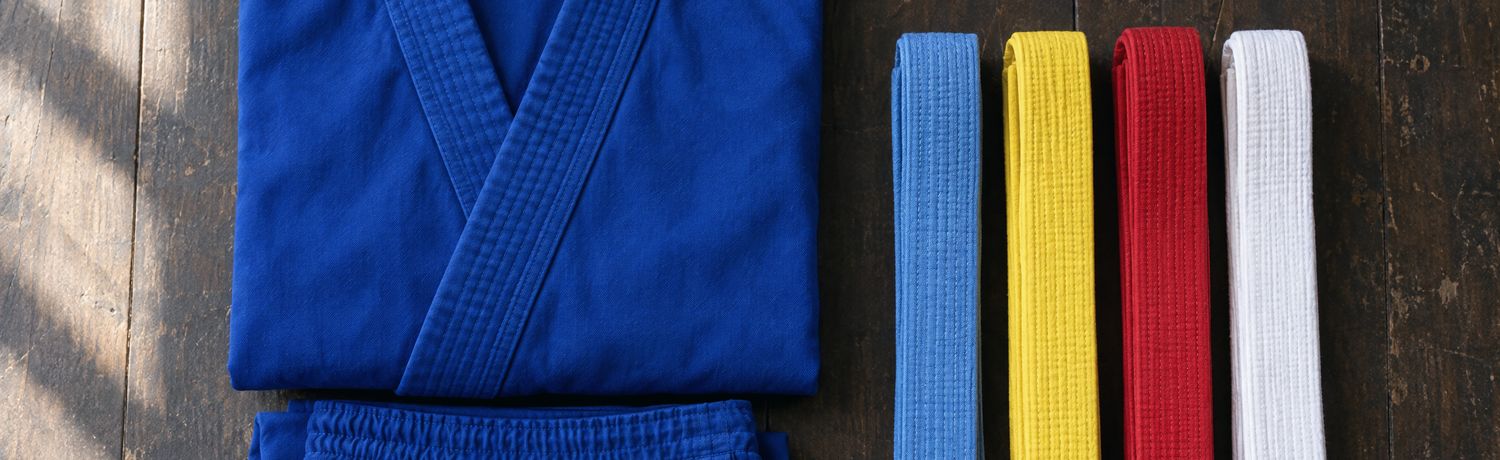 Võ phục azul doblado junto a los cuatro cinturones del Vovinam: azul, amarillo, rojo y blanco